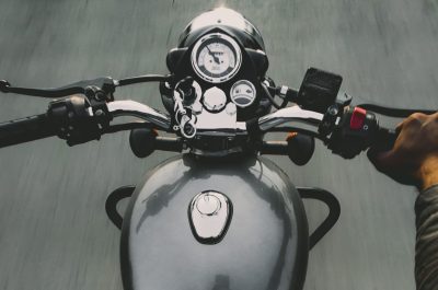 Dynamic POV shot of a person riding a motorcycle, capturing handlebars and speed.